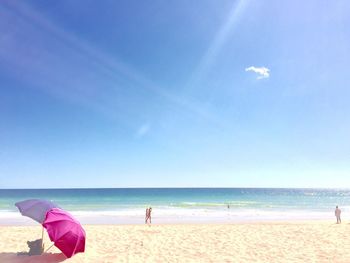 Scenic view of beach against blue sky