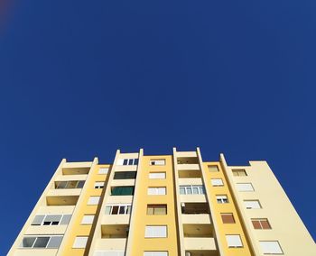 Low angle view of building against clear blue sky