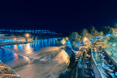 High angle view of illuminated bridge over city at night