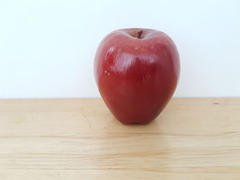 Close-up of apple on table against white background