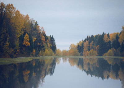 Scenic view of lake by trees against sky