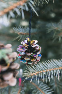 Diy handmade painted pine cone decoration on a christmas tree
