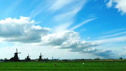 Wind turbine on landscape against clear sky