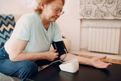 Side view of young man using mobile phone while sitting at home