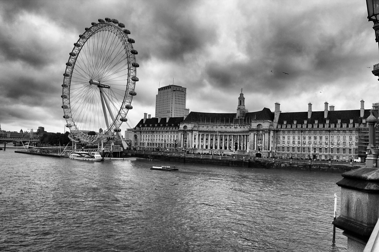 architecture, building exterior, built structure, ferris wheel, sky, water, cloud - sky, city, waterfront, cloudy, arts culture and entertainment, amusement park ride, amusement park, travel destinations, river, famous place, tourism, cloud, travel, thames river