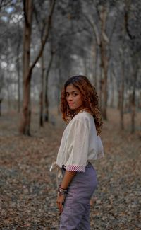 Portrait of beautiful young woman standing on land