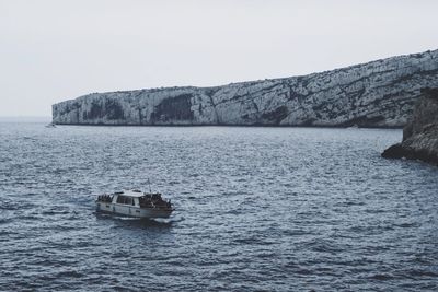 Boat sailing on sea against clear sky