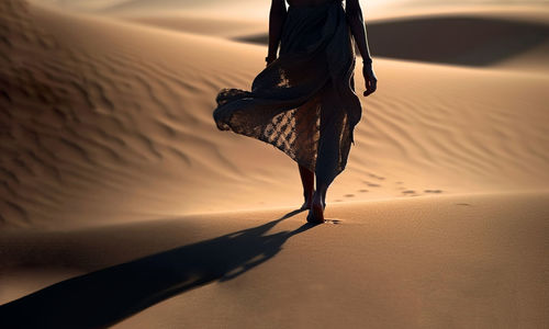 Low section of woman standing at beach