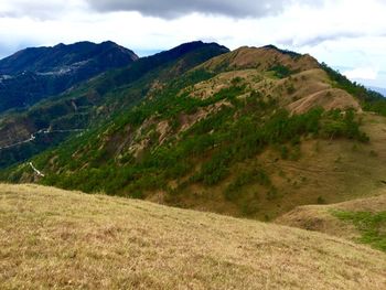 Scenic view of mountains against cloudy sky