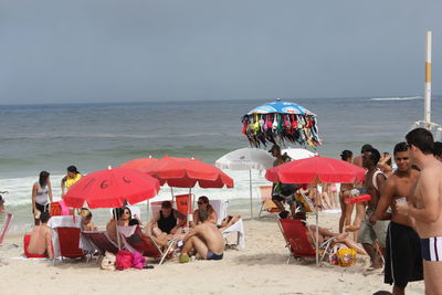 People on beach against clear sky