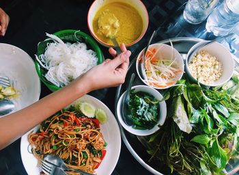 Cropped hand having food at table