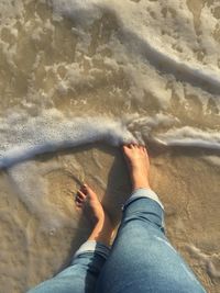 Low section of woman standing on beach