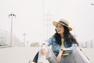 Portrait of smiling young woman against sky