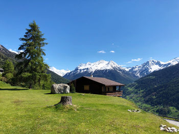 Scenic view of field and mountains against blue sky