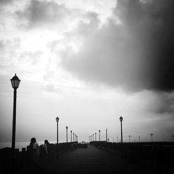 Street light against cloudy sky