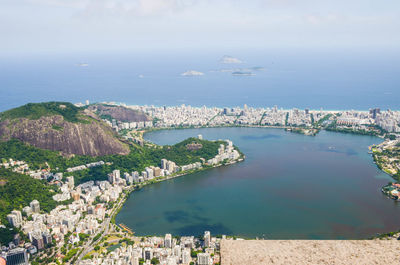 High angle view of cityscape by sea against sky