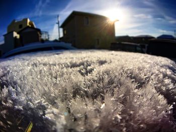 Close-up of snow on field against sky during winter