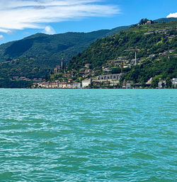 Scenic view of sea by buildings against sky