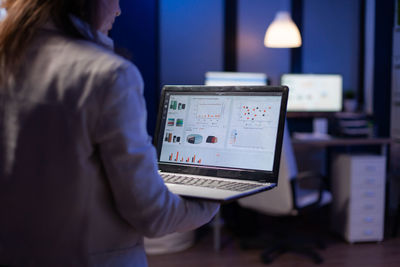 Rear view of woman using laptop