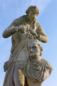 Low angle view of angel statue against sky