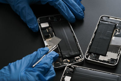 Technician repairing the smartphone's motherboard in the lab with copy space.