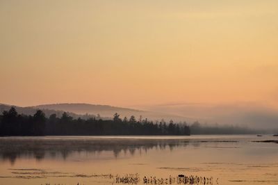 Scenic view of lake against orange sky