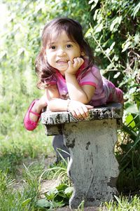 Portrait of girl lying in seat at park