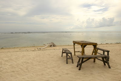 Chairs on beach against sky