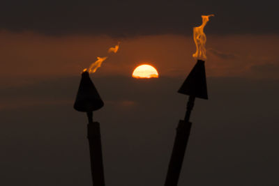 Close-up of illuminated lamp against sky at night