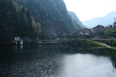 Scenic view of lake by buildings against sky