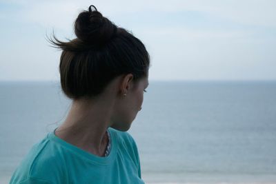 Close-up of young woman against sea