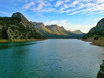 Scenic view of calm lake against cloudy sky