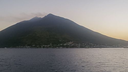 Scenic view of sea and mountains against sky during sunset