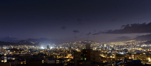 High angle view of illuminated city against sky at night