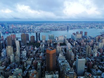 Aerial view of city against cloudy sky