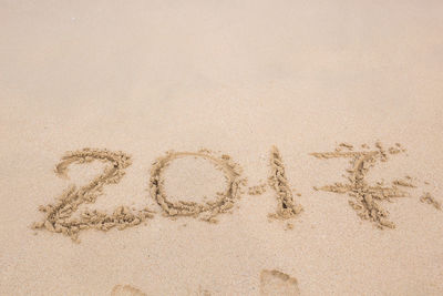 High angle view of text on sand at beach