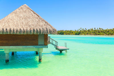 Lifeguard hut on beach against clear blue sky