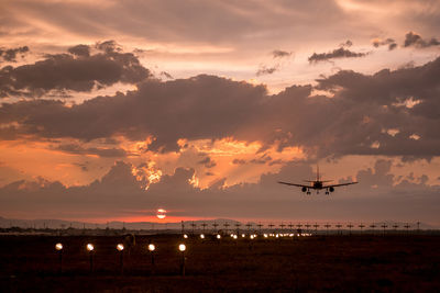 Airline plane lands at the sunset with scenic clouds