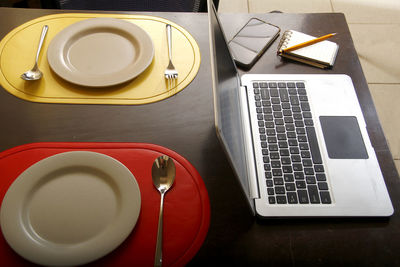 High angle view of coffee and laptop on table