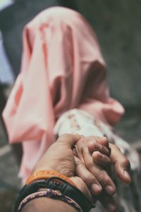 Cropped hand of man holding girlfriend outdoors