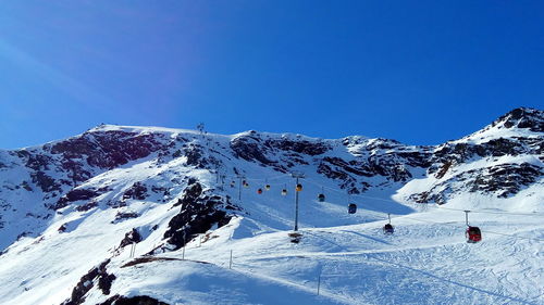 Scenic view of snowcapped mountain against blue sky