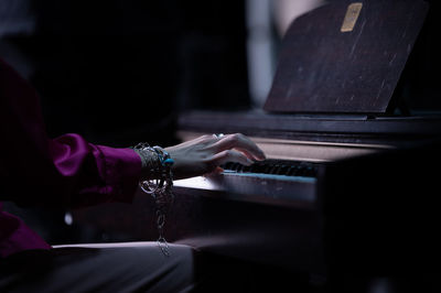 Midsection of man playing piano