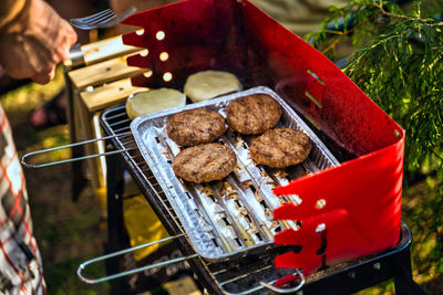 Close-up of person preparing food on barbecue grill