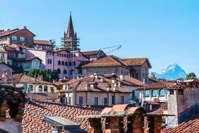 Buildings in city against clear blue sky