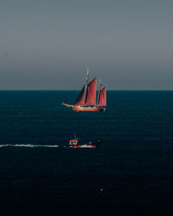 Sailboat sailing on sea against clear sky