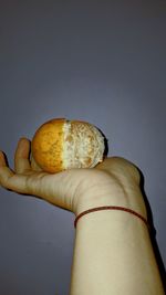 Close-up of hand holding apple against white background