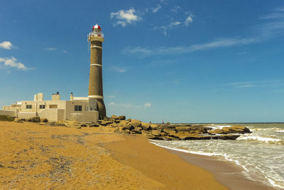 Tower by sea against sky