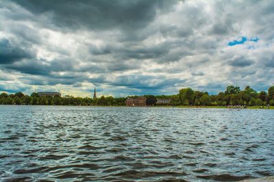 Scenic view of river against cloudy sky