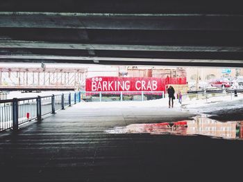 Man walking under bridge
