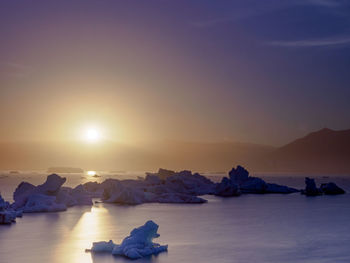 Scenic view of frozen sea against sky during sunset